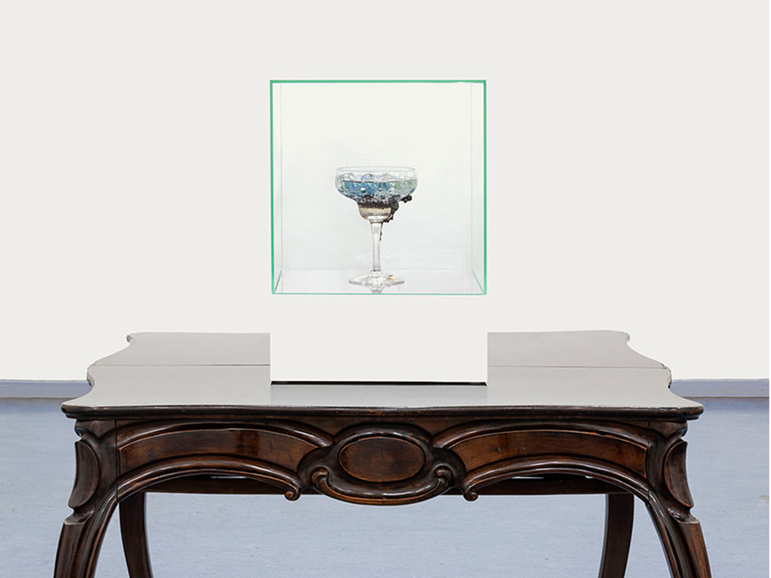Ane Graff, The Goblets (Alzheimer's Disease), 2019. 42 × 30 × 30 cm.
Glass goblet containing: mercury, silver, tin, zinc, copper (from dental amalgam); Arsenic, cadmium, lead, silica dust and polycyclic aromatic hydrocarbons (from Marlboro cigarettes); Clonazepam (from Klonopin Oral Tablets anti-anxiety medication); polycyclic organic hydrocarbons, organophosphate flame-retardants, phthalates, benzothiazoles, musk compounds, plasticisers, magnetite and silica dust (from road and tunnel dust); aluminium zirconium tetrachlorohydrex Gly, cyclopentasiloxane, ppg-14 butyl ether, phthalates (from Dove Sensitive antiperspirant stick); maltitol, sorbitol, xylitol, steviol glycosides, ammonium salt, gum arabic, glycyrrhizin, E153, gum arabic (from sugar free salt liquorish pastilles); diacetyl, perfluorooctanoic acid, tertiary-butyl hydroquinone, trans fats (from microwave popcorn); saccharomyces cerevisiae yeast, mold, gluten, hardened rapeseed oil (from molded white bread); potassium aluminum sulfate (from deodorant); glucose fructose, syrup, glycerol, E133, corn syrup, starch, E420, salt, sugar (from blue icing color); calcium silicate, sodium (from table salt); inorganic copper powders, aluminum salts, and crushed glass in epoxy laminating resin mix. Photo: RH Studio.